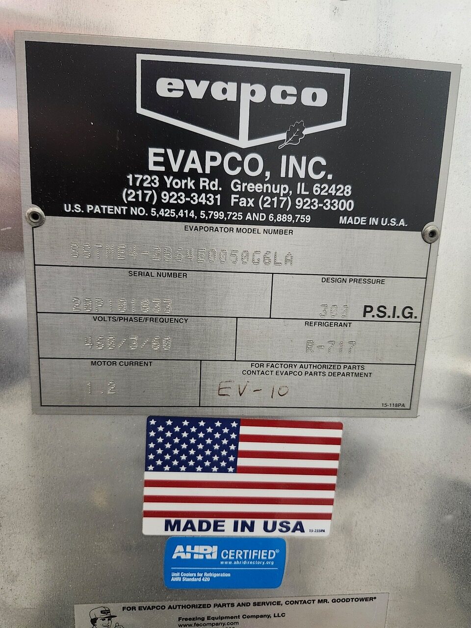 Metal equipment nameplate reading EVAPCO, INC. with address, patent numbers, serial number, design pressure, refrigerant R-717, and motor current; below it is a small American flag sticker and a 'MADE IN USA' label with an AHRI sticker.