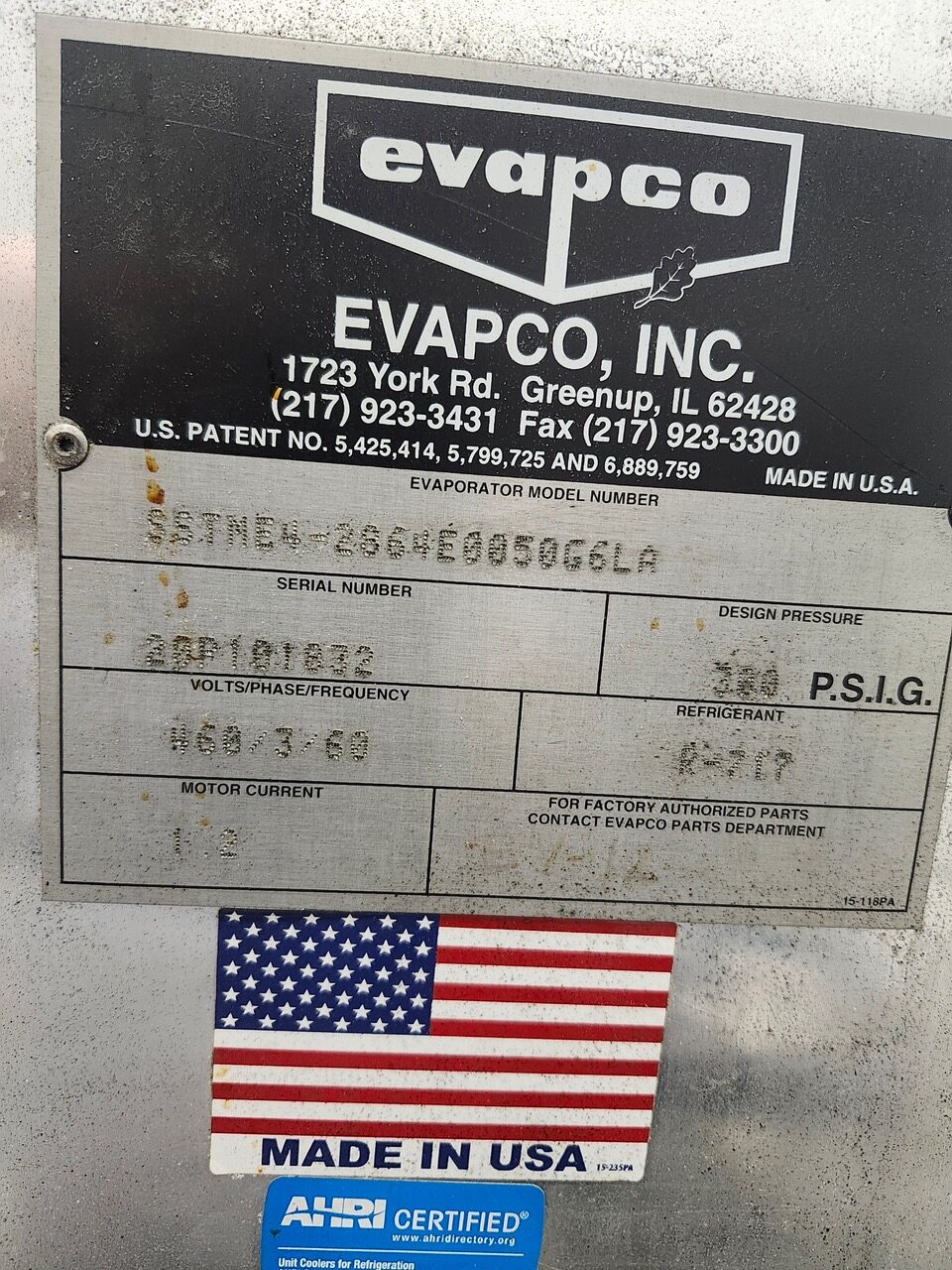 Industrial Evapco data plate on equipment with serial/model numbers, design pressure, and electrical specs; 'MADE IN USA' label and American flag beneath.