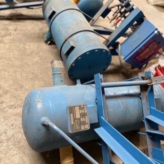 Blue industrial air compressor system with cylindrical tanks and mounting frame on a concrete floor.