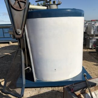Blue-topped white cylindrical industrial tank on a blue base, with a large wheel-lever mechanism mounted beside it outdoors.