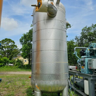Industrial metal vertical silo with insulated elbow pipe and damaged top cover outdoors near machinery
