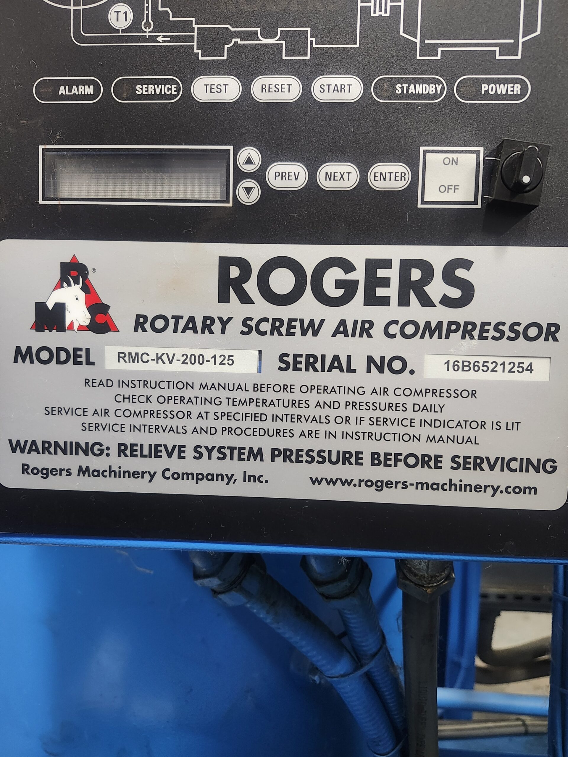 Close-up of a Rogers rotary screw air compressor control panel showing model RMC-KV-200-125, serial number, and instruction text with blue hoses below.