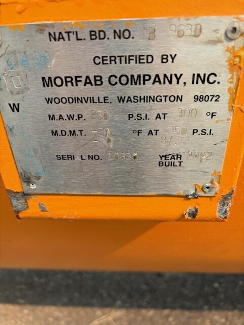 Metal certification plate on bright orange equipment: reads Morfab Company, Woodinville, Washington; includes serial/pressure fields and build year